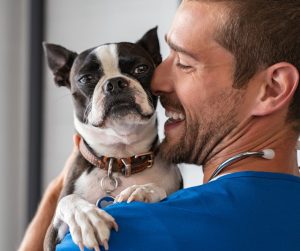 Dog being held by happy dog owner